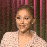 a close up of a woman 's face against a pink curtain