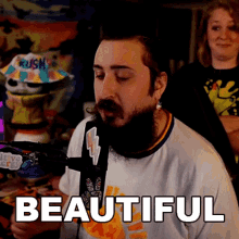 a man with a beard is wearing a white shirt that says " beautiful "
