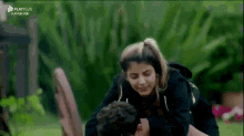 a man is giving a woman a piggyback ride in a park .