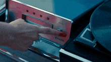 a person is pressing a button on a maxxx device