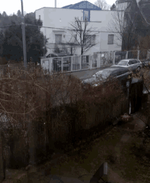 a car is parked in front of a white building with a sign that says ' a ' on it
