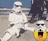 a storm trooper sits in the sand next to a smiley face