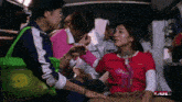 a woman in a red shirt with the word princess on it sits in an ambulance