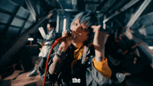 a person singing into a microphone with the word the on the bottom right