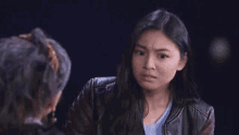 a young woman is talking to an older woman in a dark room .
