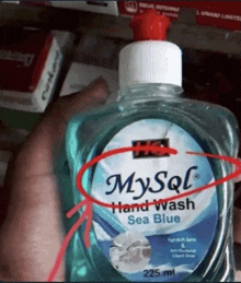 a hand is holding a bottle of mysql hand wash