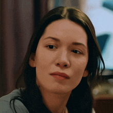 a close up of a woman 's face with a serious expression