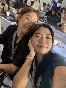 two women posing for a picture with one wearing a lanyard that says ipac