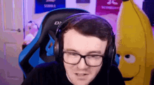 a man wearing glasses and headphones is sitting in a blue chair .