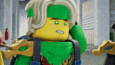 a lego character with a green scarf around his neck has a surprised look on his face
