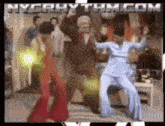 a group of people are dancing in front of a sign that says nyrhythm.com