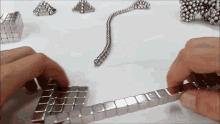 a person is playing with a bunch of metal balls