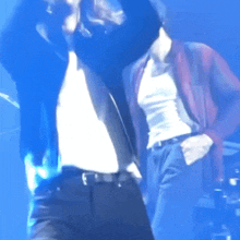 a man in a white tank top and black pants is dancing on stage