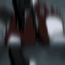 a blurred image of a person 's feet with a red shoe in the background