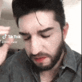 a man with a beard is making a funny face and has a tiktok watermark on his face