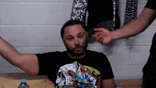 a man with a beard wearing a black shirt with a spider man design on it