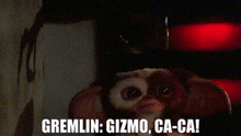 a close up of a red light with the words `` gremlin : gizmo , ca-ca '' written on it .
