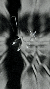it is a black and white photo of a broken glass window .