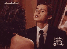 a man in a suit and tie is looking at a woman in a dress