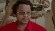 a man wearing sunglasses and a red shirt