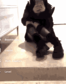 a woman is sitting on the floor taking a picture of herself in the mirror