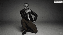 a black and white photo of a man wearing sunglasses and a get the app advertisement