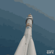 a person making a peace sign in front of a rocket that is made with gifx