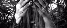 a woman is covering her face with her hands in a black and white photo