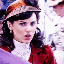 a woman wearing a straw hat and a red coat