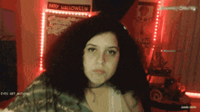 a woman 's face is visible in front of a happy halloween sign
