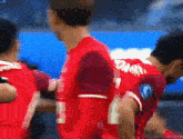a group of soccer players wearing red uniforms with the number 7 on the back