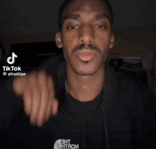 a man wearing a black hoodie with the north face logo on it