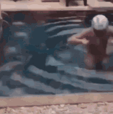 a man is swimming in a pool with a helmet on .