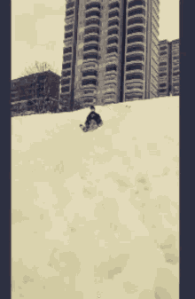 a person is sliding down a snow covered hill
