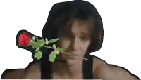 a man is holding a red rose in front of his mouth