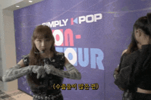 a girl stands in front of a sign that says simply kpop on tour