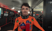 a man wearing an orange jacket that says " android " on it