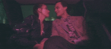 a man and a woman are kissing in a car