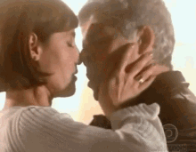 a man and a woman are kissing each other .