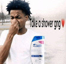 a man is holding his nose next to a bottle of head & shoulders shampoo