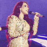 a woman with red hair is singing into a microphone on a stage