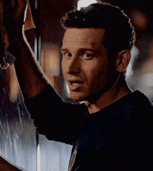 a man wipes a window with a cloth and looks at the camera