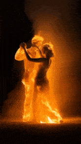 a man and a woman are dancing in the dark and they are made of fire