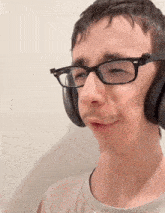 a man wearing glasses and headphones making a face