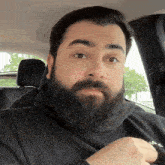 a man with a beard is wearing a black shirt with the word me on it