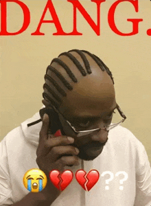a man wearing glasses is talking on a cell phone with a broken heart emoji