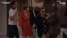 a group of people are dancing in front of a hulu logo
