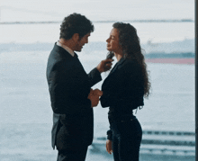 a man and a woman are standing next to each other and looking at each other