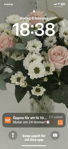 a phone screen shows a bouquet of flowers and the time 18:38