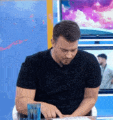 a man sitting at a table with a glass of water